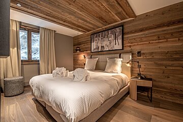 A bedroom with a bed and a picture on the wall