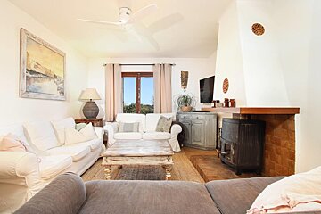 A living room with white furniture and a fireplace