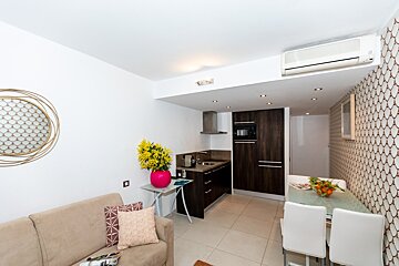A living room with a couch and a kitchen