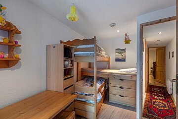 A room with a bunk bed and a rug that says ' a ' on it