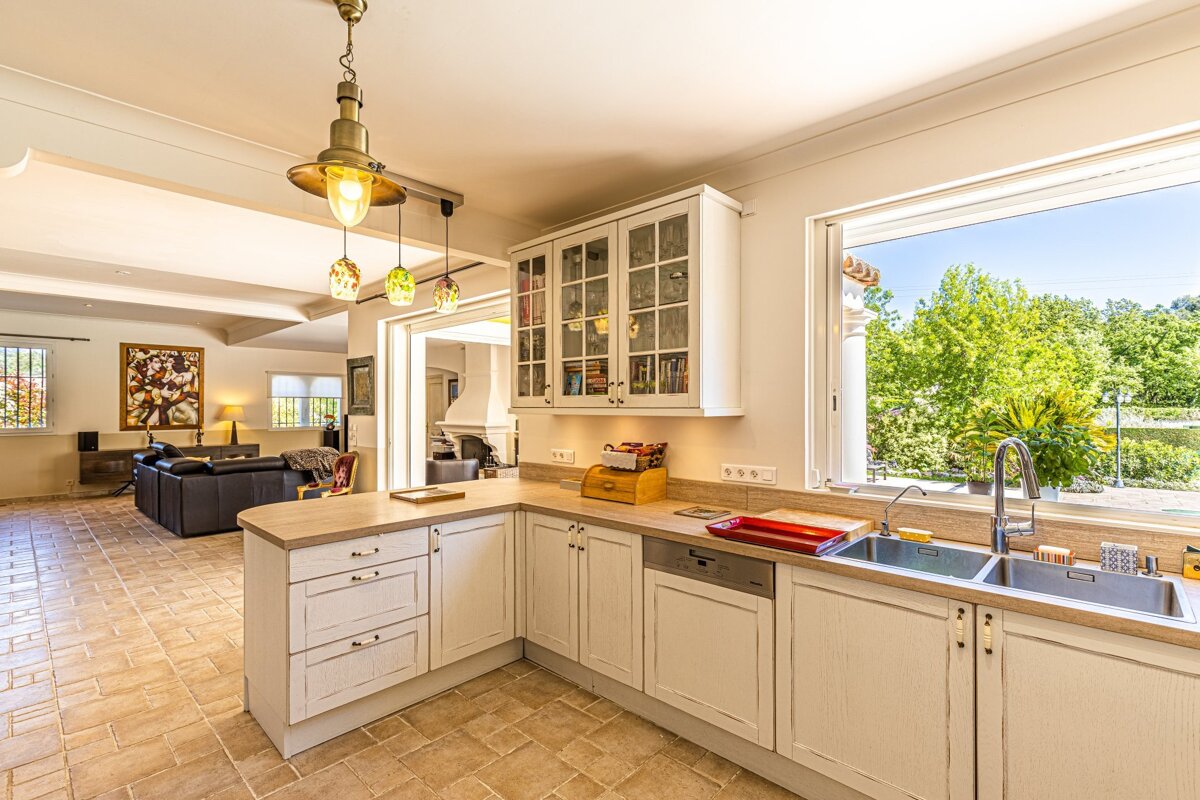 A kitchen with white cabinets and a sink