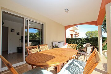 A table and chairs on a patio with a sliding glass door
