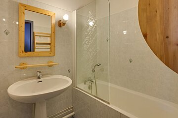 A bathroom with a sink a mirror and a bathtub