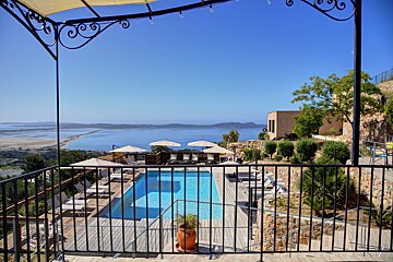 A view of a swimming pool from a balcony overlooking the ocean