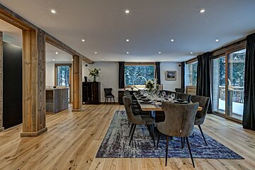 A dining room with a long table and chairs