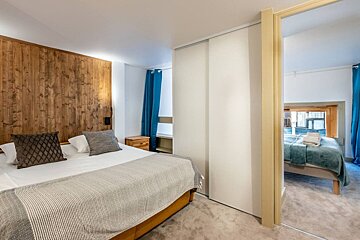 A bedroom with a large bed and a closet