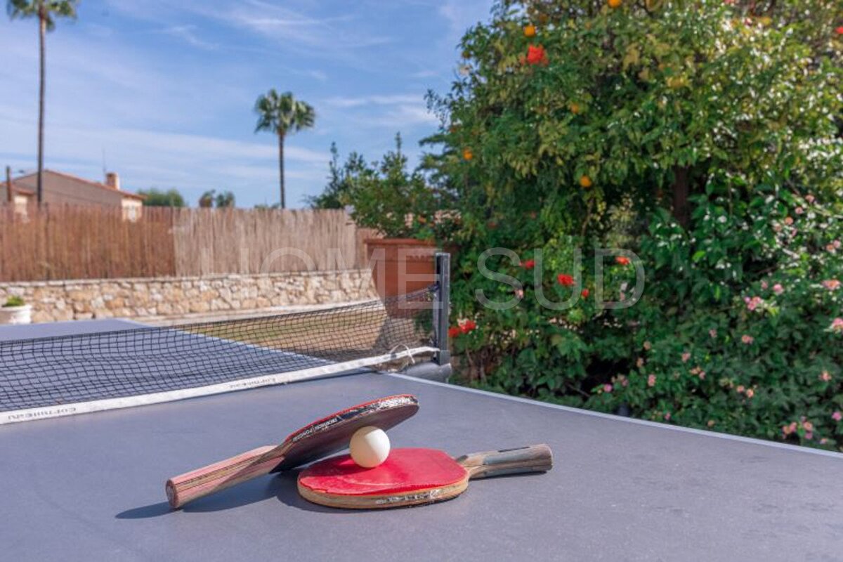 Two ping pong rackets and a ball on a table with the word 