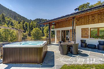 A hot tub sits outside of a mountain base real estate property