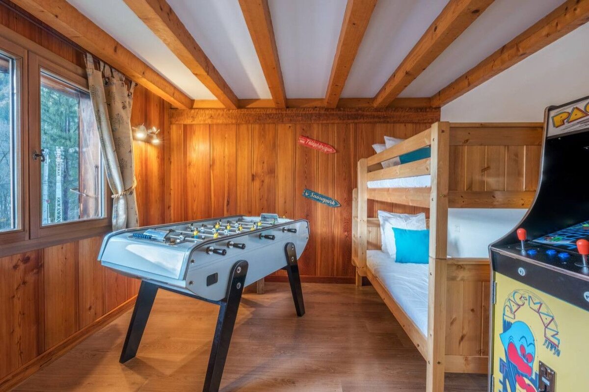 A room with bunk beds and a pac man arcade game