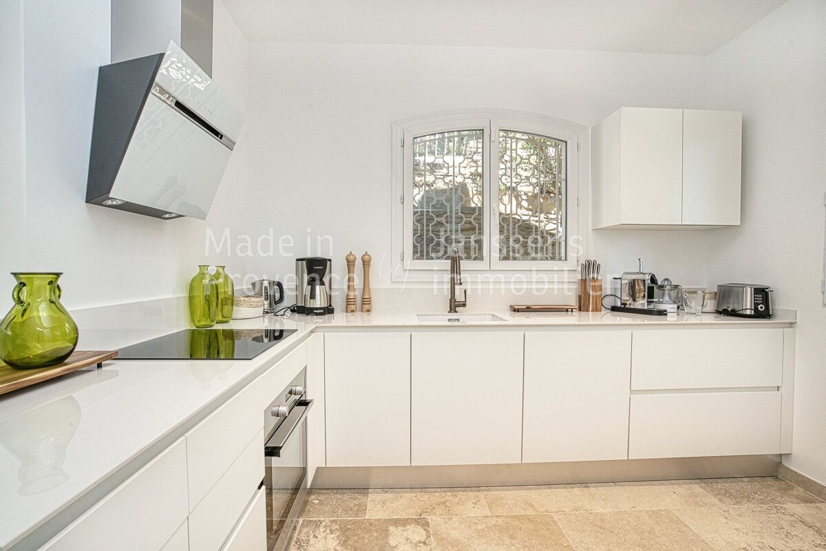 A kitchen with white cabinets and appliances and the words made in on the bottom