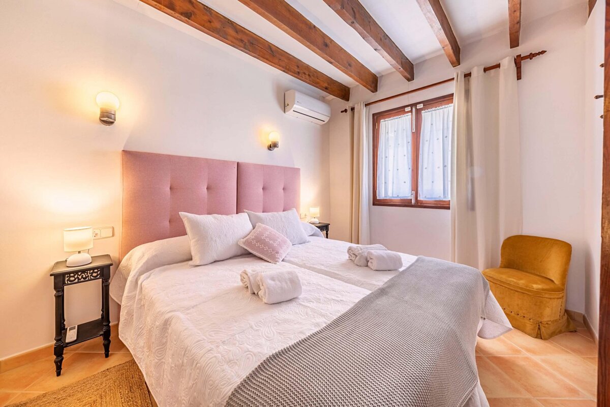 A bedroom with a pink headboard and a yellow chair