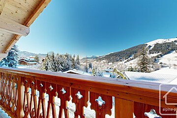 A balcony with a view of snowy mountains and a sign that says alpine-pr