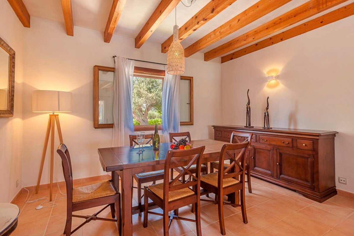 A dining room with a wooden table and chairs