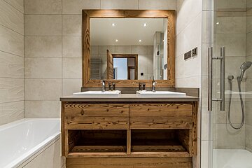 A bathroom with two sinks and a large mirror