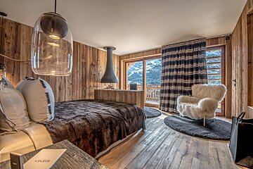 A bedroom with a bed and a chair and a book that says ' spirit ' on it