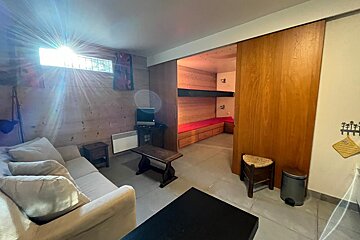 A living room with a couch and a trash can