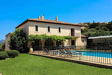 A large house with a swimming pool in front of it