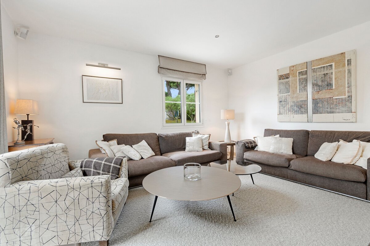 A living room filled with furniture and a painting on the wall