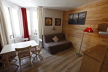 A living room with a couch and a table and chairs