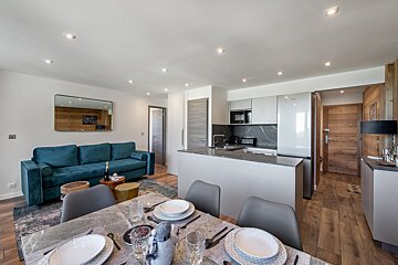 A living room with a blue couch and a dining table