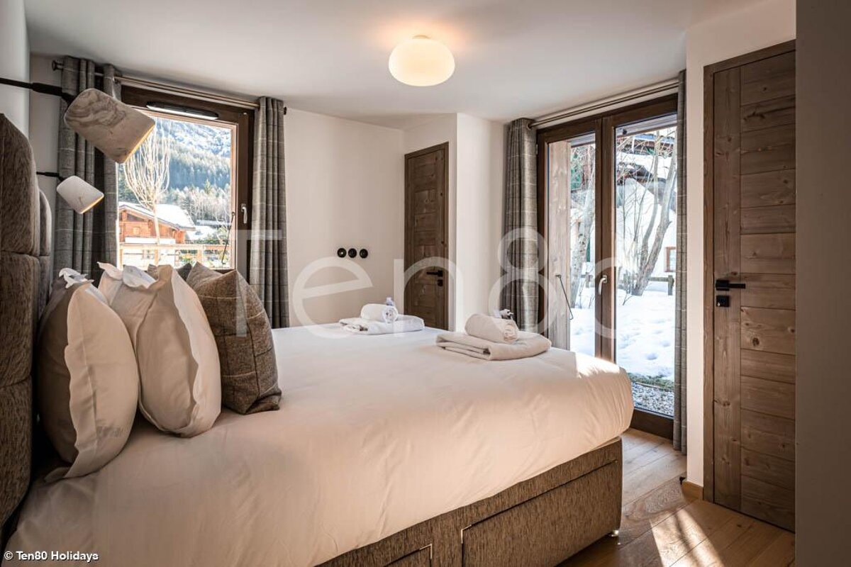 A bedroom with a bed and a window with the word ter on the bottom