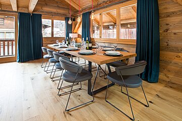 A dining room table with plates and glasses on it