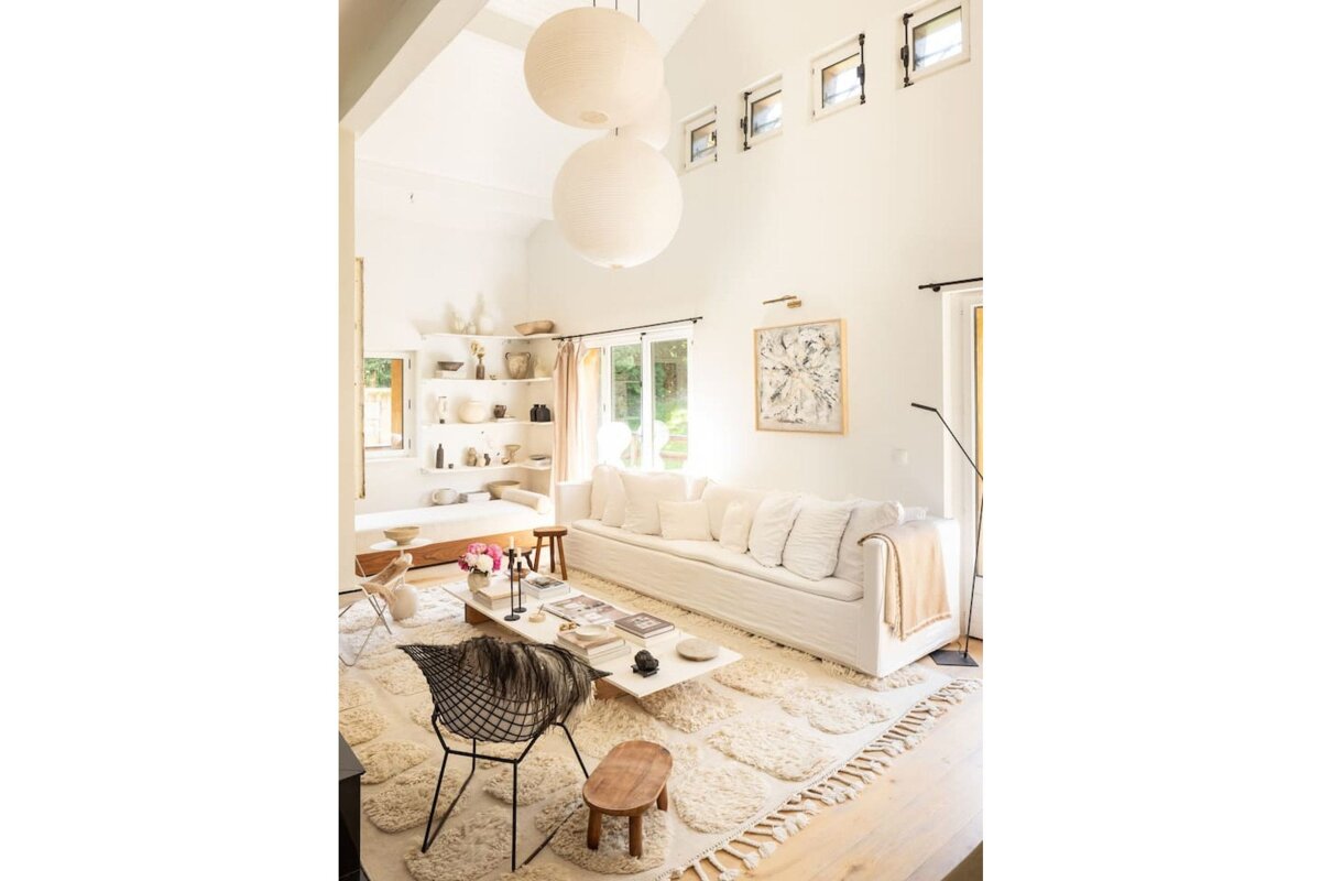 A living room with a white couch and a black chair