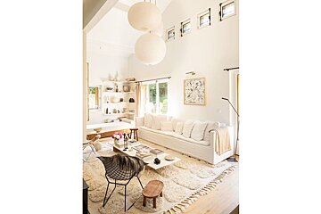 A living room with a white couch and a black chair