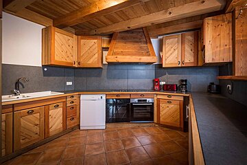 A kitchen with wooden cabinets and a white dishwasher