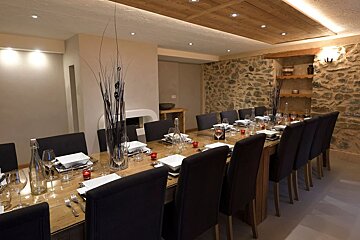 A long dining table with plates and candles on it