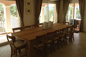 A dining room with a long wooden table and chairs