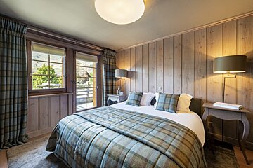 A bedroom with a large bed and two lamps