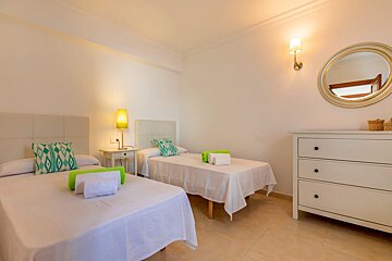 A bedroom with two beds and a dresser