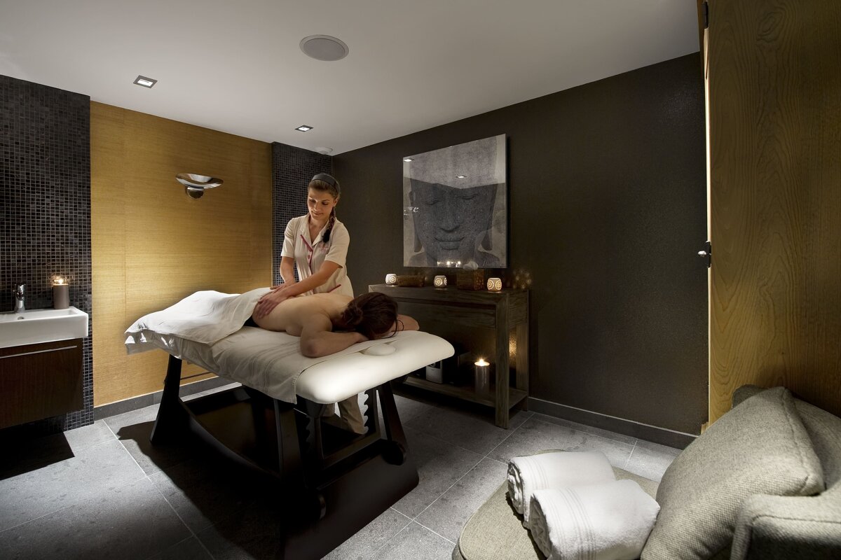 A woman is giving a man a massage in a spa