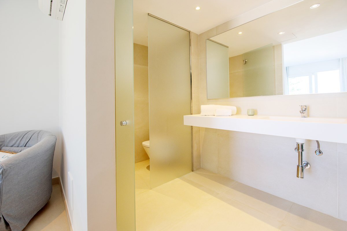 A bathroom with a toilet and a sink and a mirror