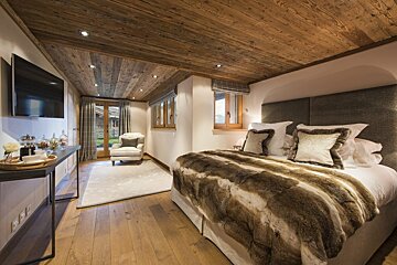 A bedroom with a large bed and a flat screen tv