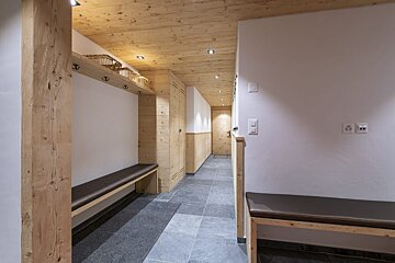 A hallway with a bench and hooks on the wall