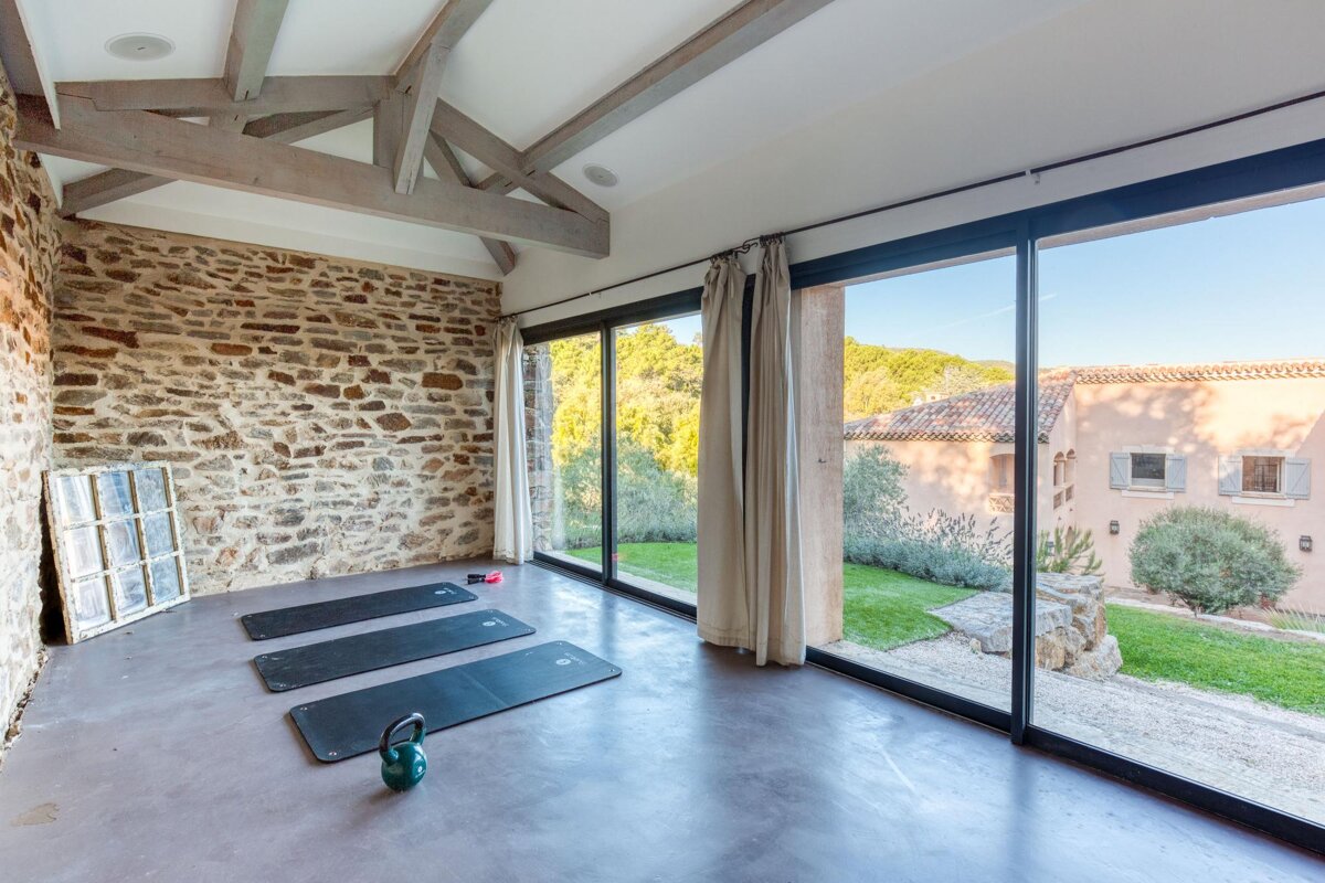 A room with three yoga mats and a kettlebell on the floor