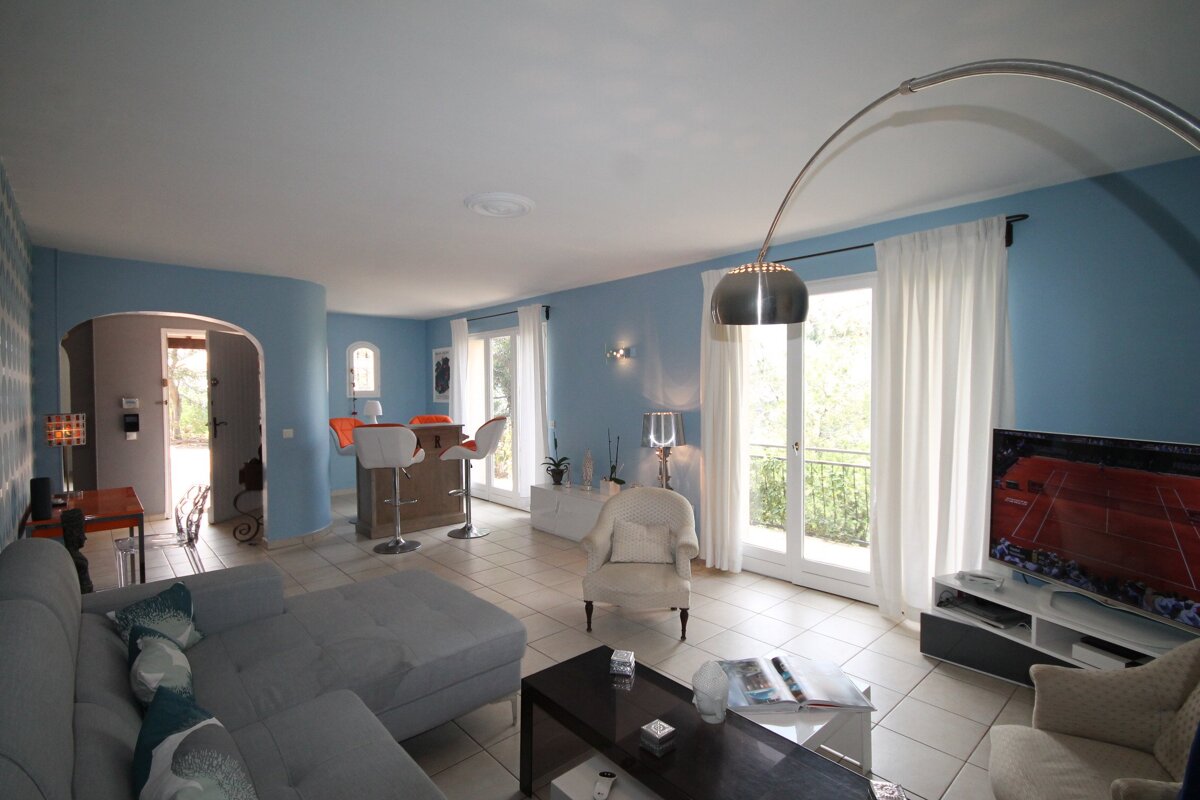 A living room with blue walls and white curtains
