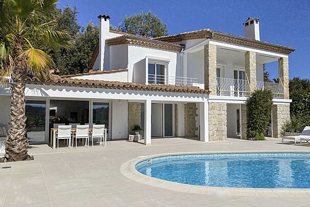 A large white house with a swimming pool in front of it