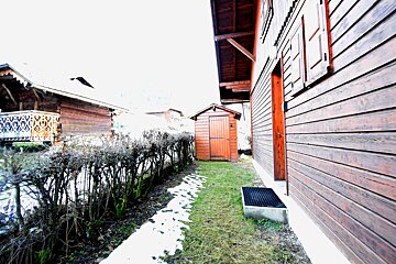 A wooden house with a shed in front of it