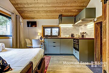 A room with a bed and a kitchen with the words mountain base on the bottom