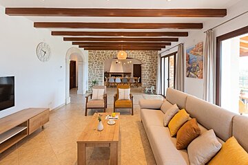 A living room with a couch and chairs and a clock on the wall