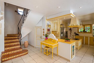 A kitchen with yellow cabinets and a yellow desk