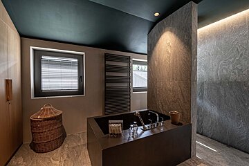 A bathroom with a bathtub and a window