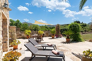 A patio with a table and chairs and a shade sail