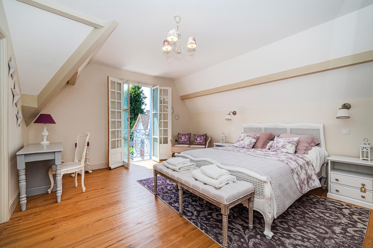 A bedroom with a large bed and a bench