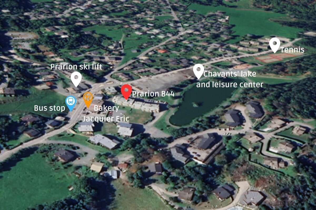 An aerial view of a small town with a bakery and a tennis court