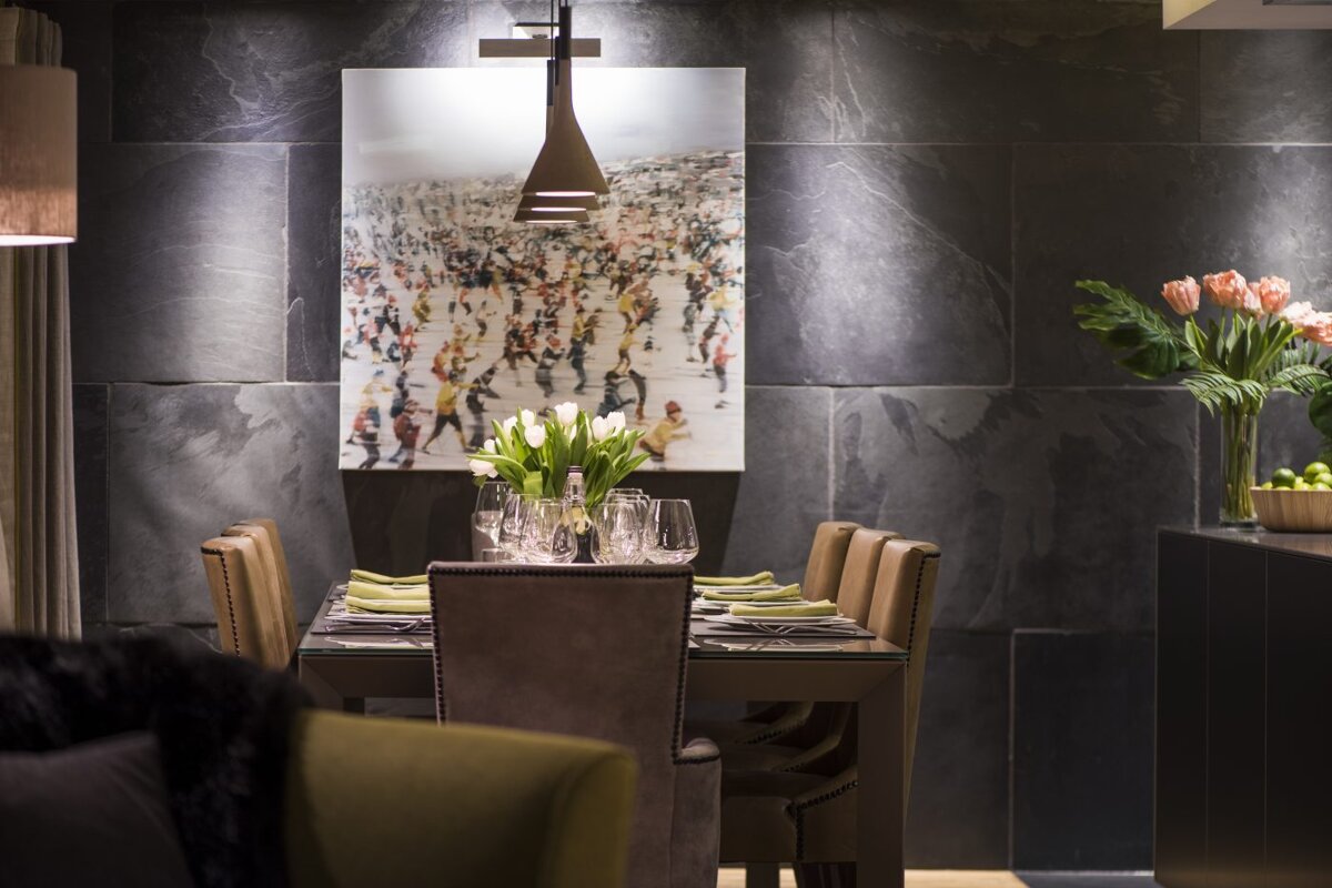 A dining room with a painting on the wall above the table