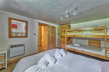 A bedroom with a bunk bed and a mirror
